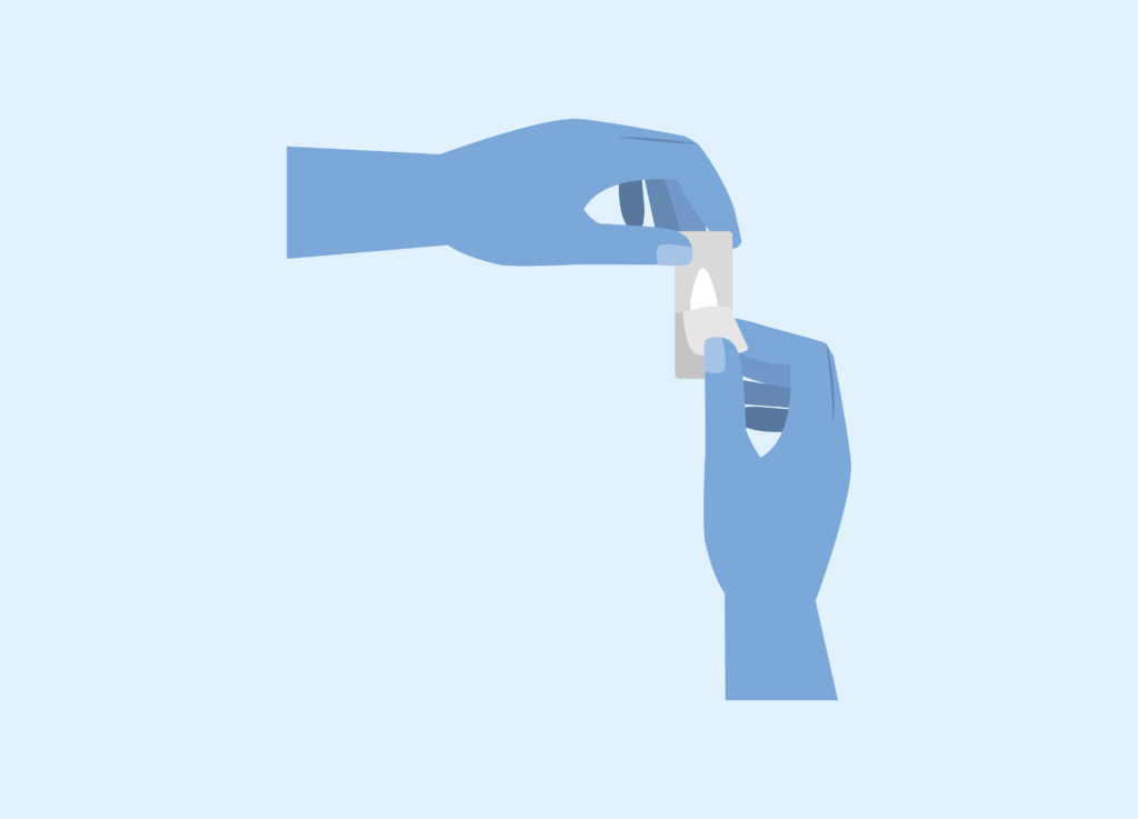 One hand holds RepaGyn ovule package while the other peels back the plastic covering